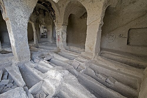 Yamaca oyulmuş kaya mekânları ve önlerindeki taş teraslar